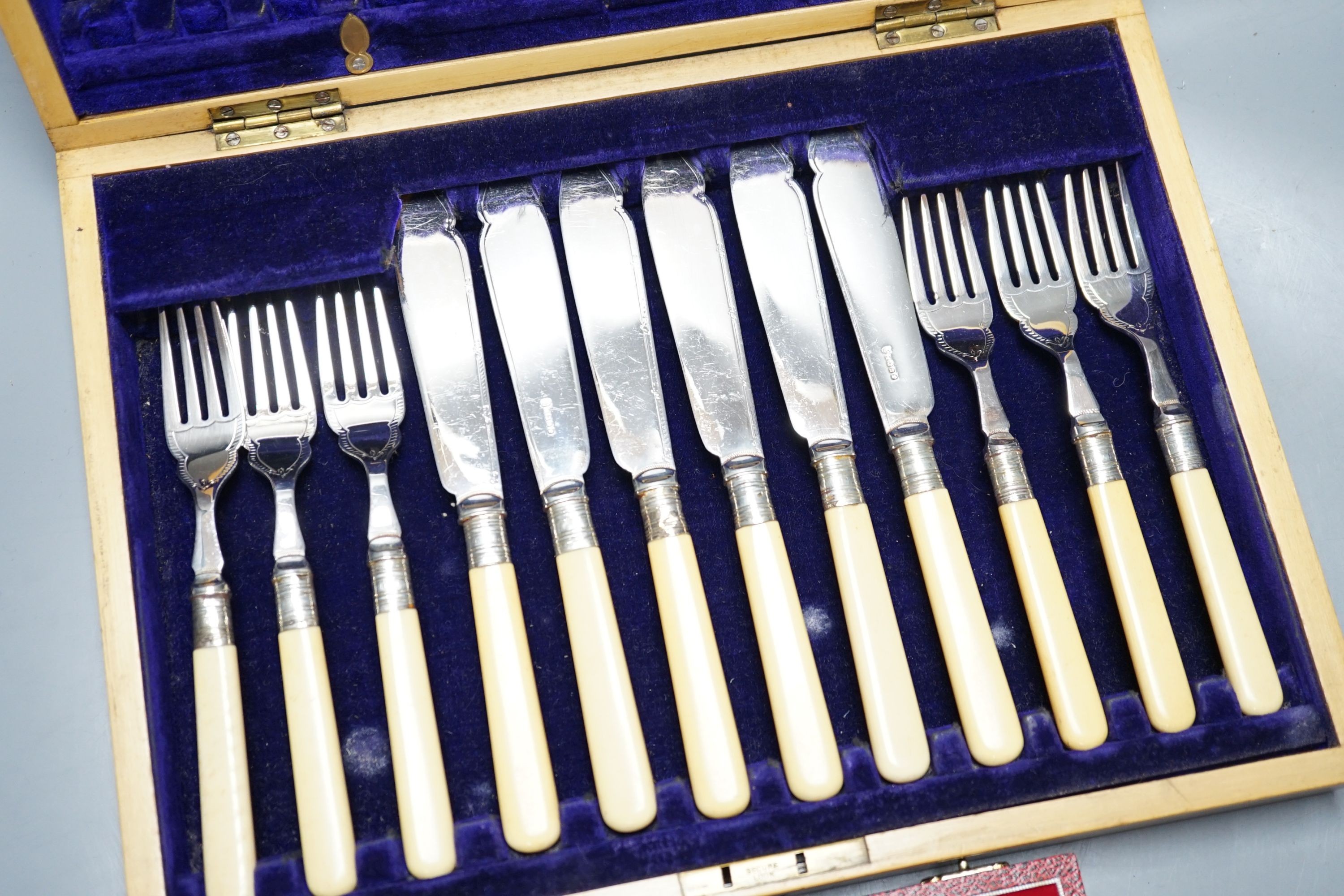 A cased modern silver three piece condiment set, a cased set of twelve Edwardian silver teaspoons, London, 1903 (lacking tongs) and two plated fish services.